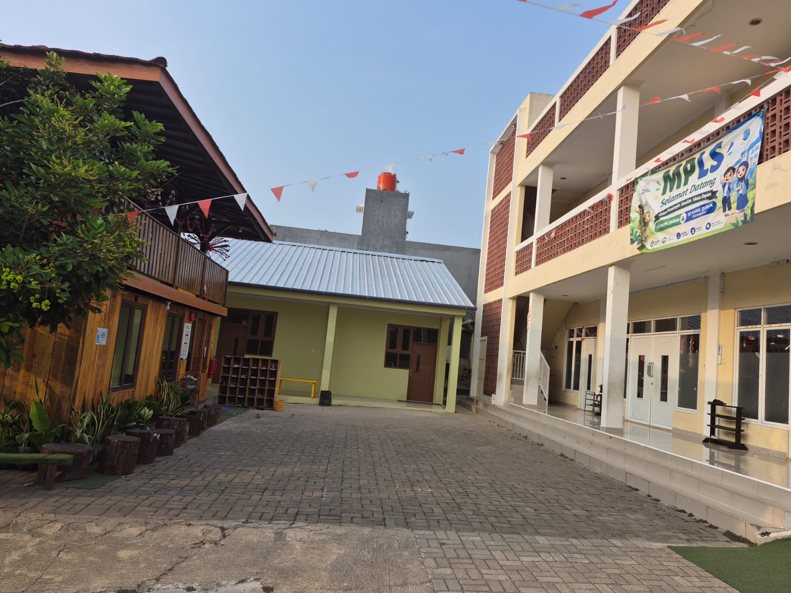 Halaman Saung Qur'an dengan bangunan saung kayu, gedung belajar, dan area bermain anak